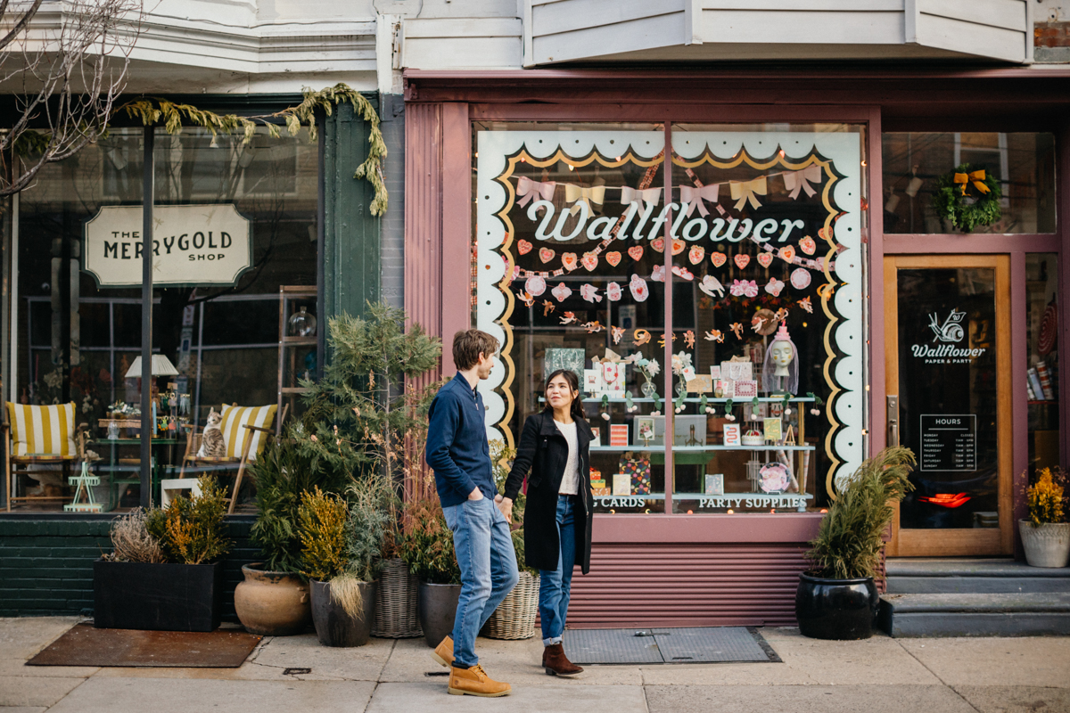 Colorful engagement photo in Queen Village with local signage
