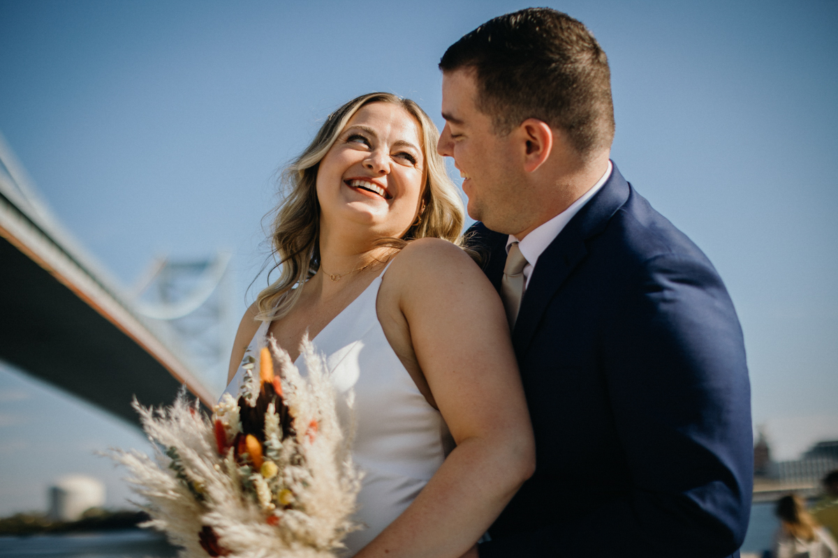 Candid reactions during first look at Race Street Pier, captured by Philadelphia wedding photographer