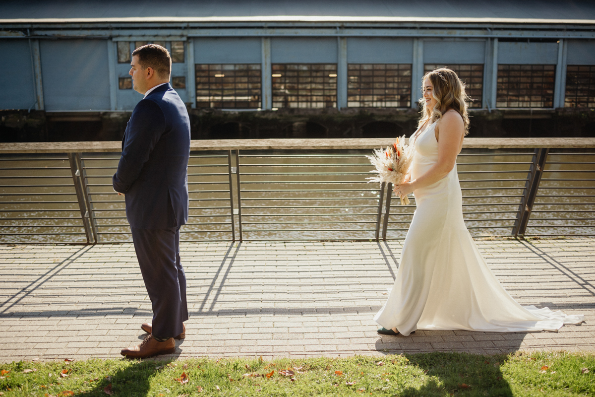 First look moment under the bridge at Race Street Pier, Philly wedding photographer