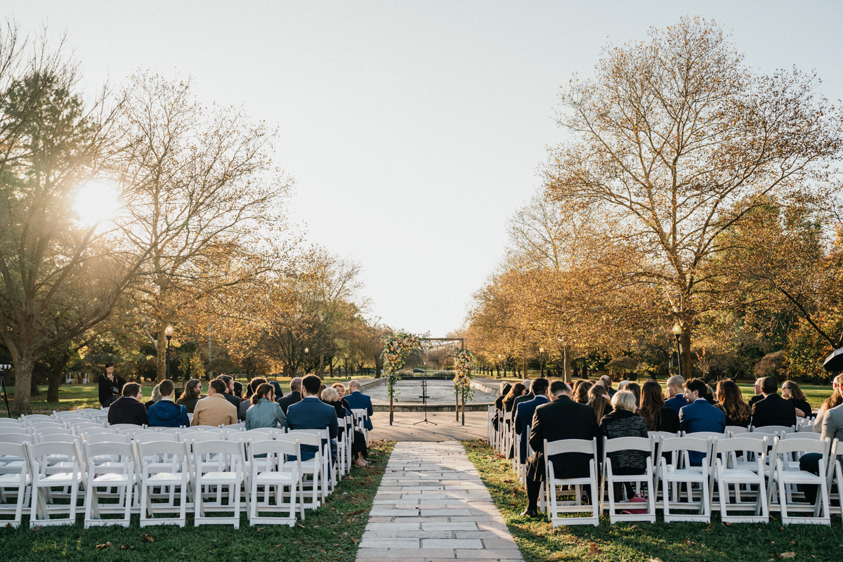 Ceremony under floral arch by wedding videographer Philly