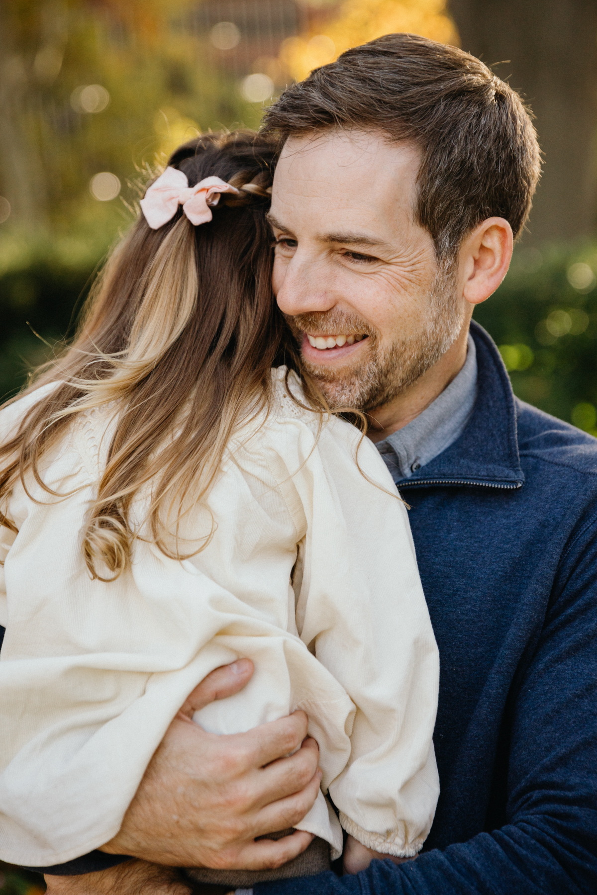 Lifestyle fall family photos in Philadelphia park with golden foliage