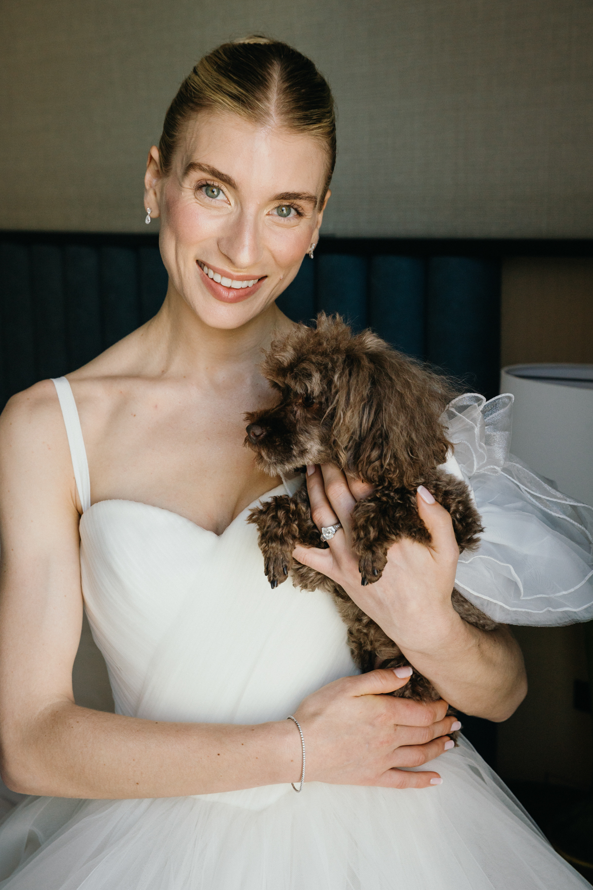 Bride smiling while holding dog at Longwood Gardens wedding