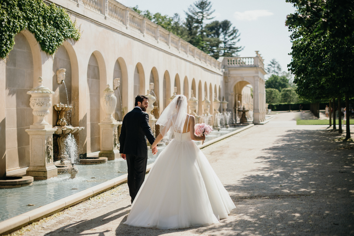 bride and groom walking near fountains at longwood gardens wedding