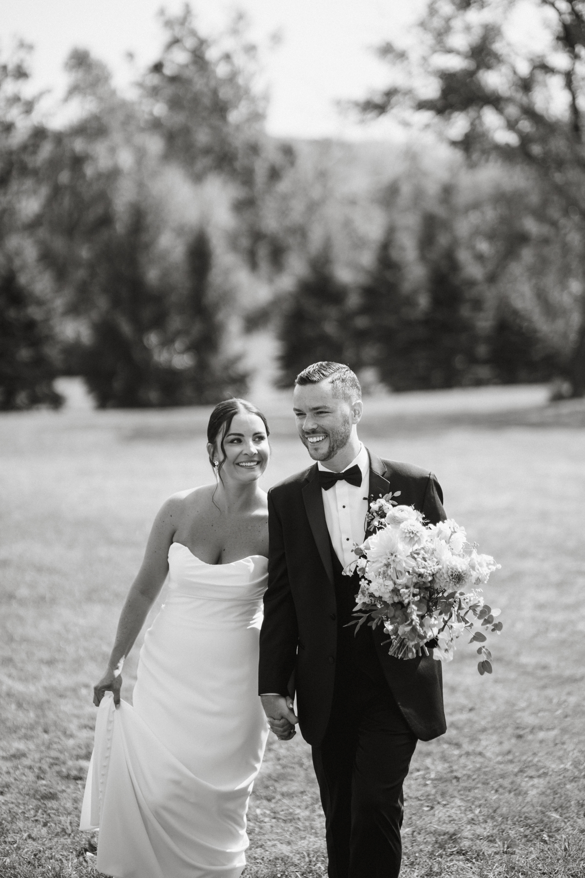Couple walking through orchard at Terrain Gardens at DelVal wedding