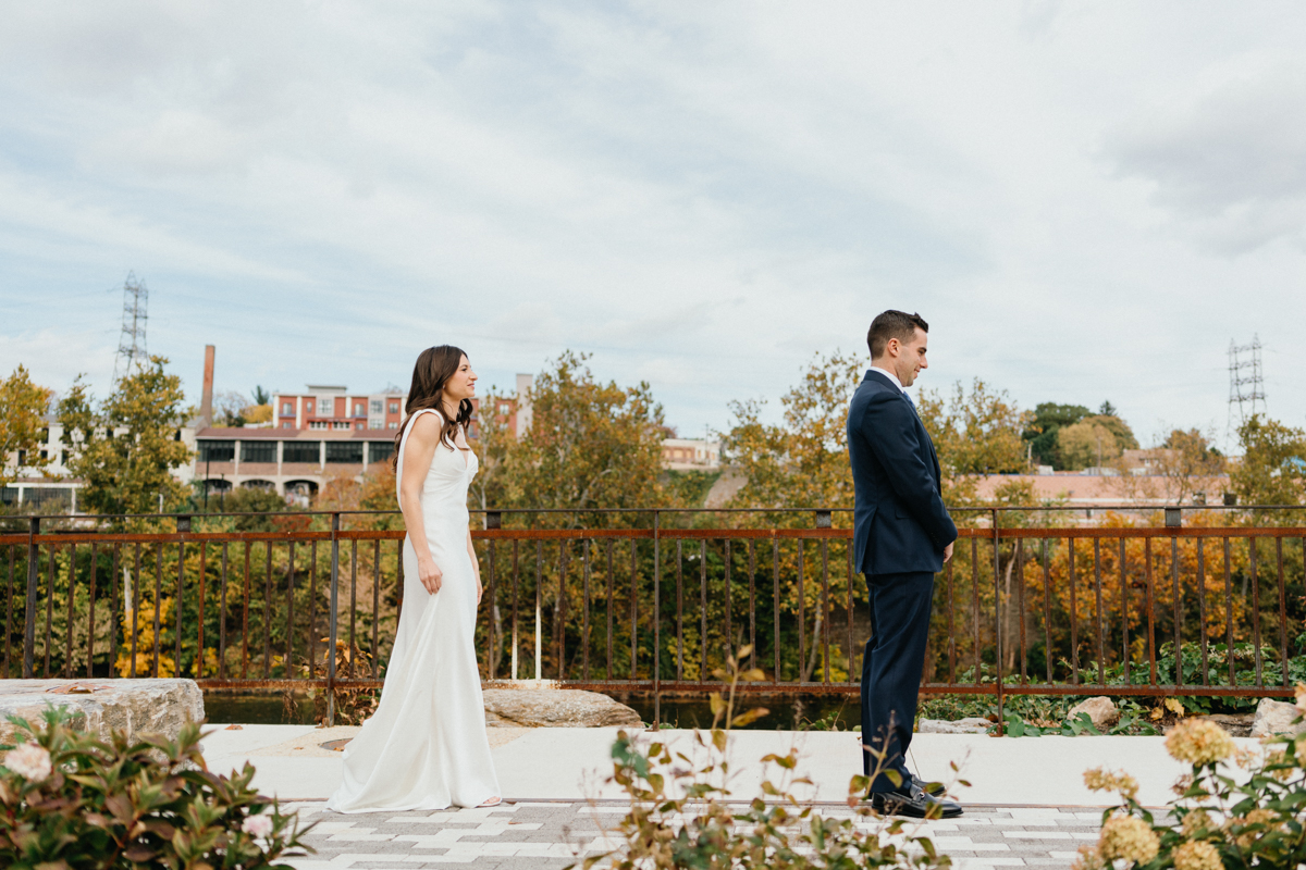 Bride walking toward groom for first look at Ironworks