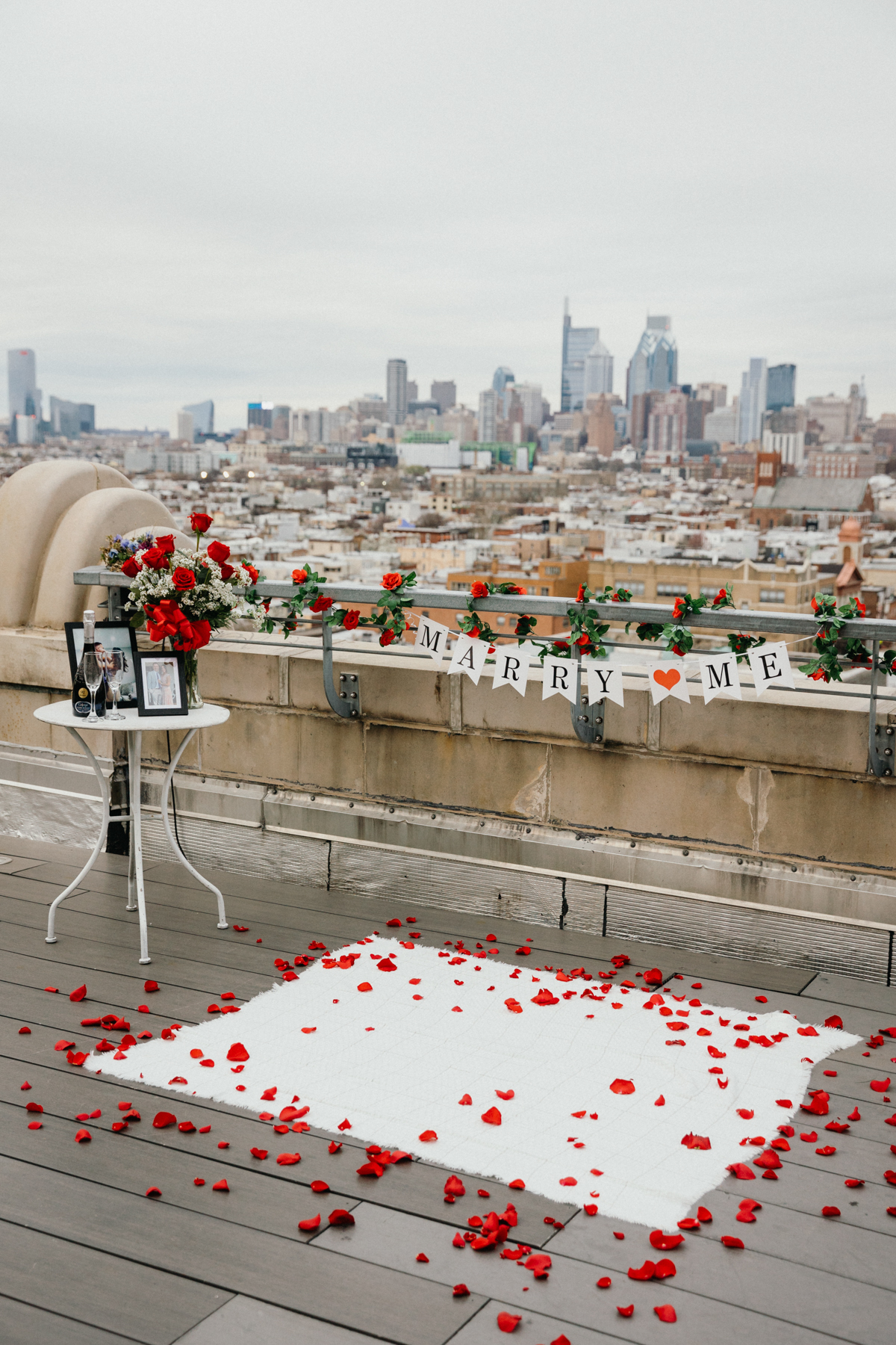 Rooftop proposal setup with blanket and flowers in Philly