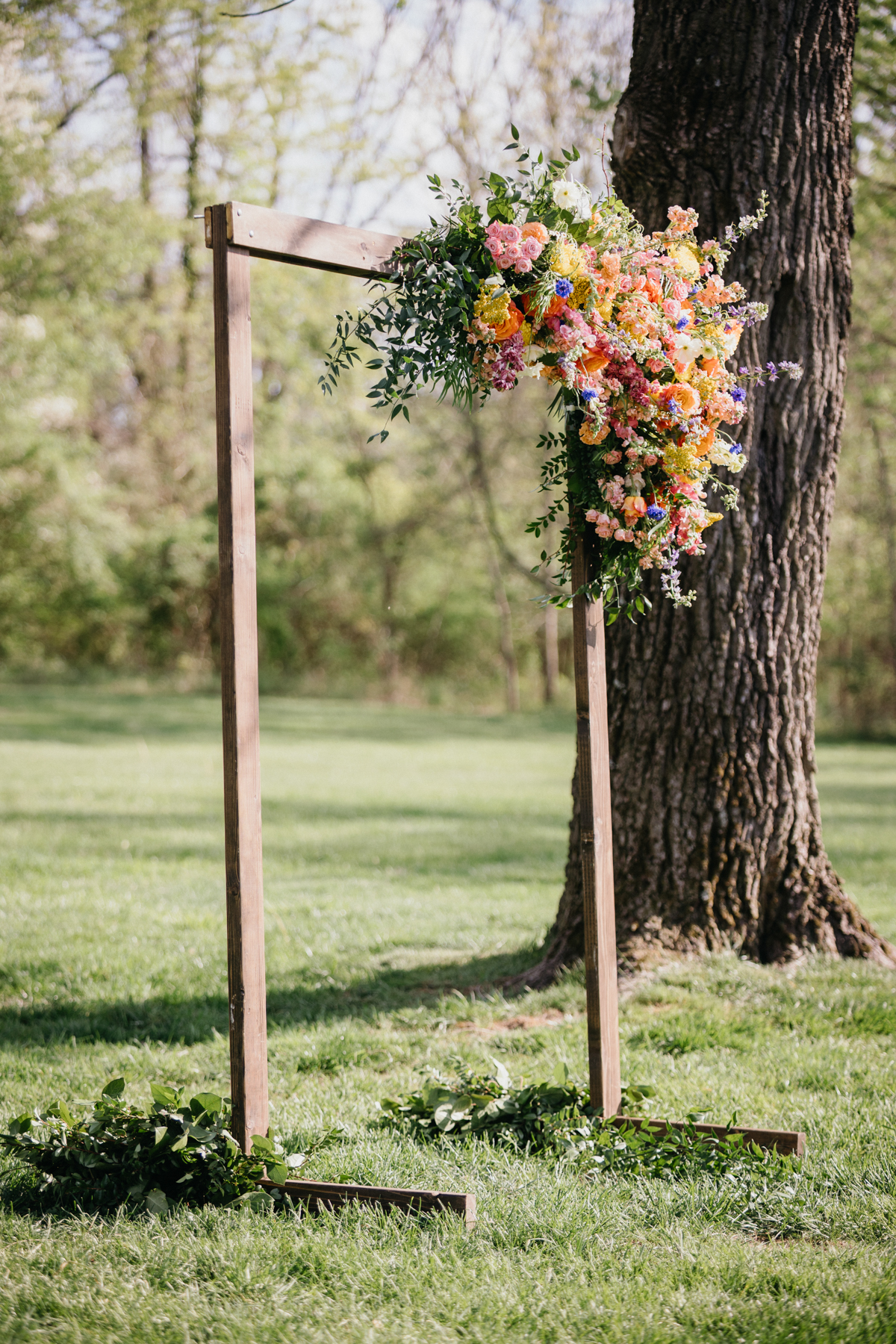 garden wedding ceremony florals on wooden arch