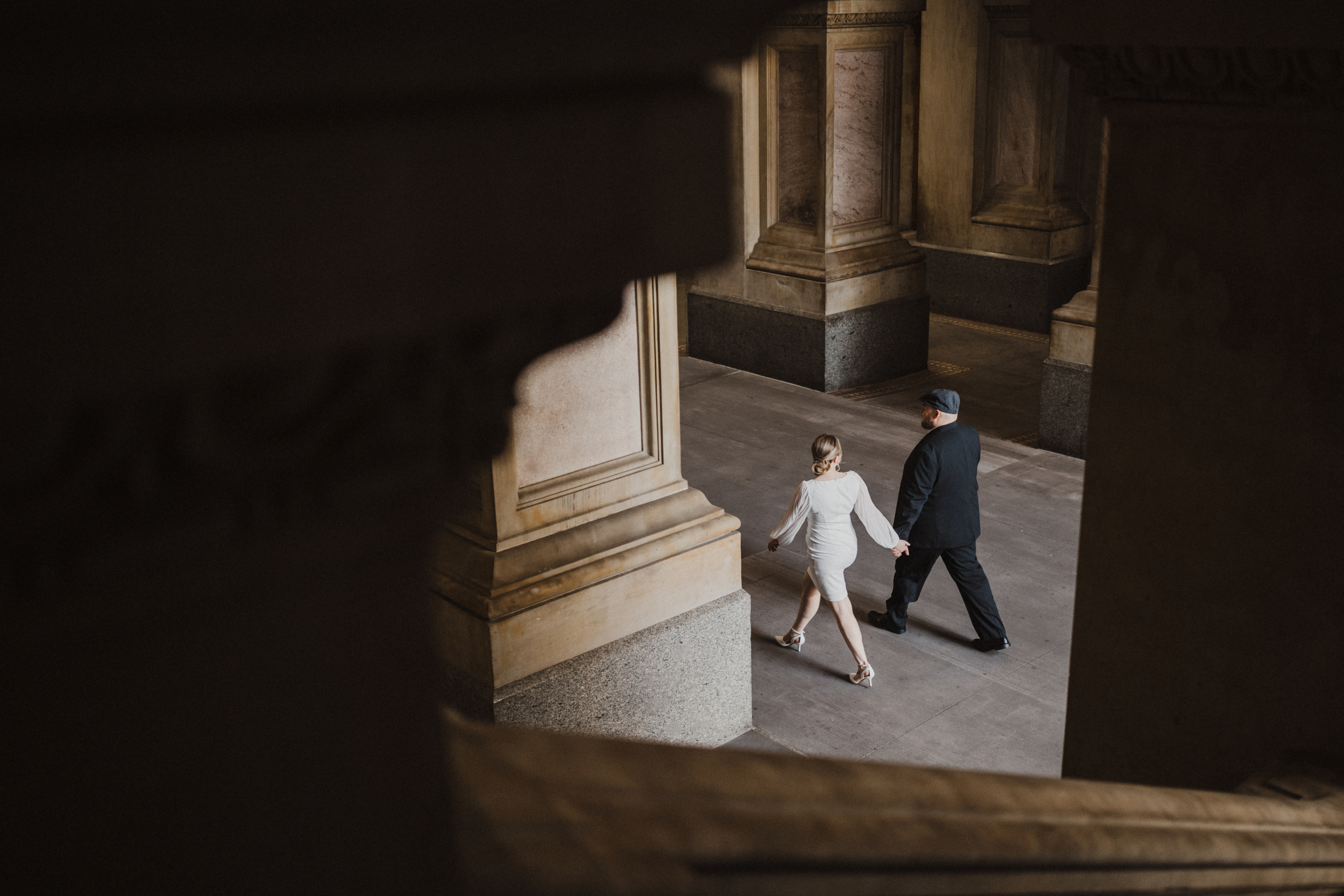 Bride and groom walking through City Hall for an editorial wedding Philly vibe